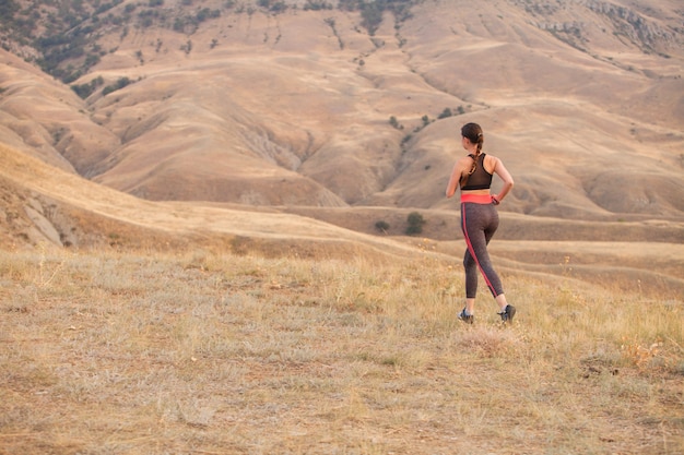 The woman runs in the mountains