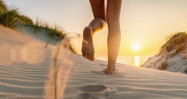 写真 女性は日没時にバルト海のビーチに向かって走ります