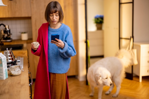 Woman rushes out of home putting on a coat and finishing her coffee