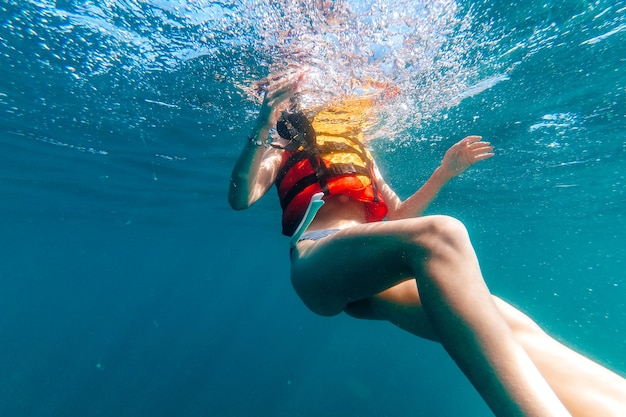 Woman's body in a life jacket floats underwater in the sea on vacation