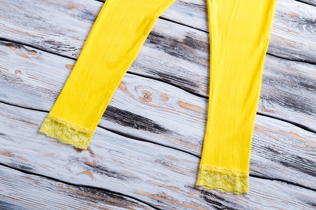 Woman's casual yellow trousers. summer pants on wooden background. soft and natural fabric. stand out from the crowd