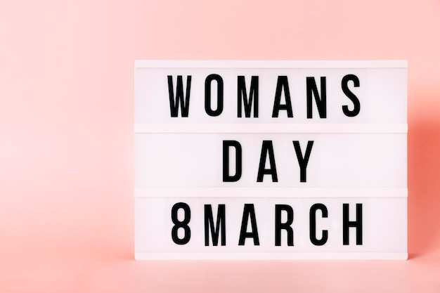 "Woman's Day, 8 maart" Lichtgevende poster met kopieerruimte. Feministische thema brieven met roze achtergrond. feminisme concept