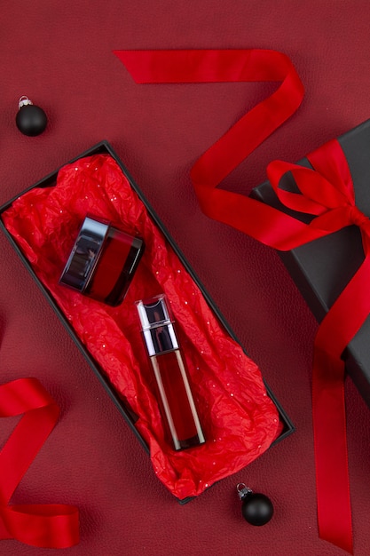 Cosmetici per la cura del viso della donna confezionati in confezione regalo nera con nastro rosso