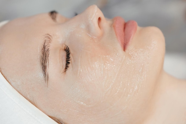 A woman's face is covered with a facial mask.