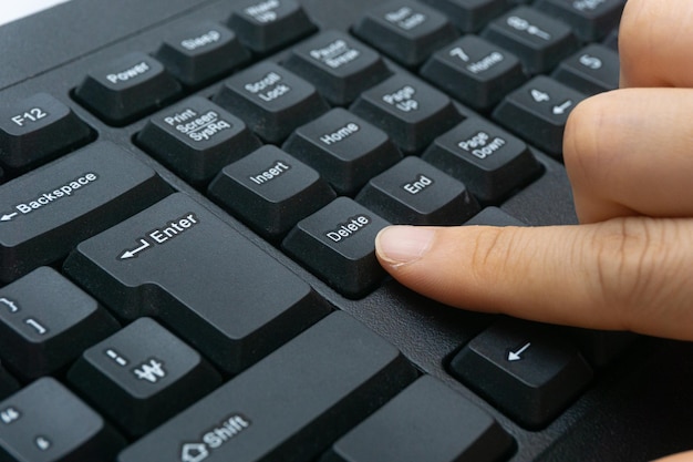 A woman's finger holding a computer keyboard