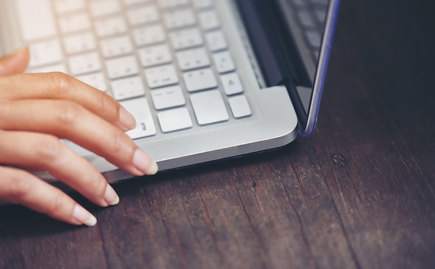 A woman\'s finger is pressing the enter key on her keyboard