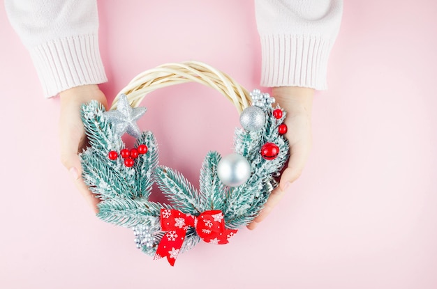 Woman's or girl hands holding Christmas wreath