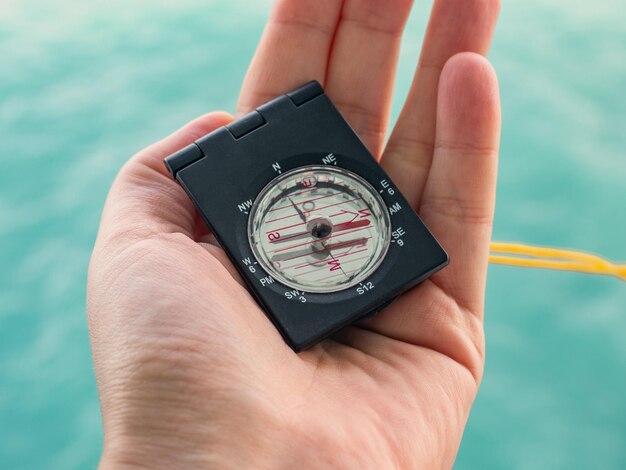 Woman's hand and compass on the background of sea