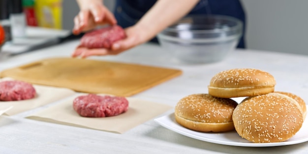 ハンバーガーパーティーのために牛肉を作る女性の手ひき肉の部分自家製ハンバーガー自宅で料理を作るクローズアップ