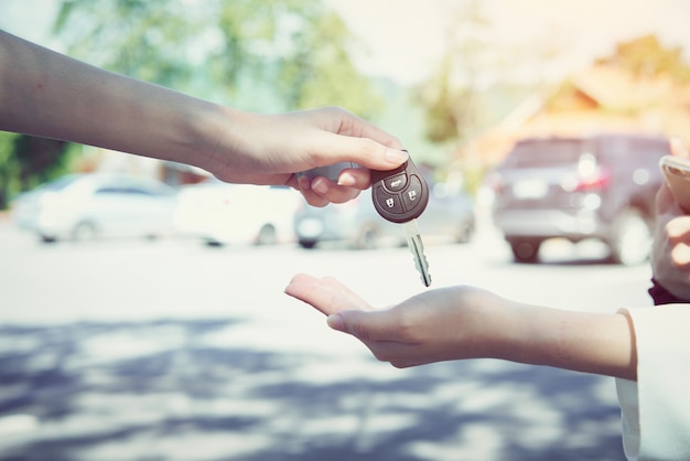 女性の手は車のキーと背景をぼかします。