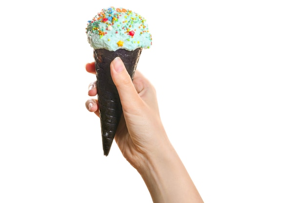 Woman's hand holding black wafer cone with blue ice cream Isolated on white