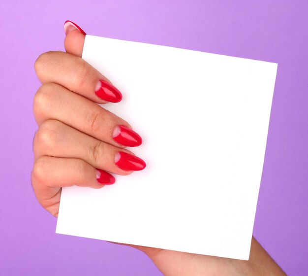 Woman's hand holding blank card on color background