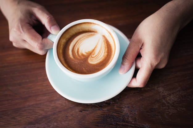 Woman's hand holding a cup of coffee