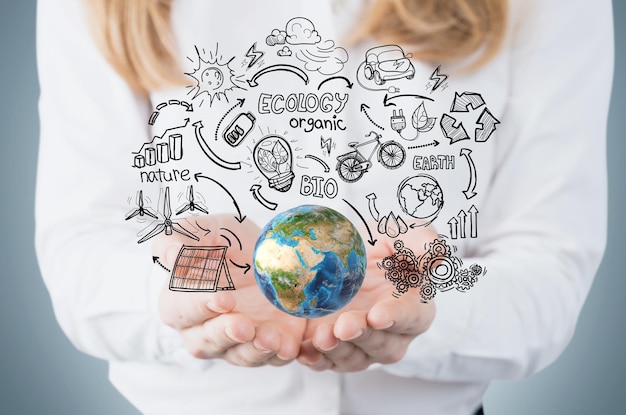 Woman's hand holding globe against blackboard