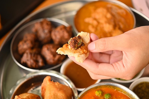 Photo woman's hand holding indian foodtop view on plate of indian food by culture of india