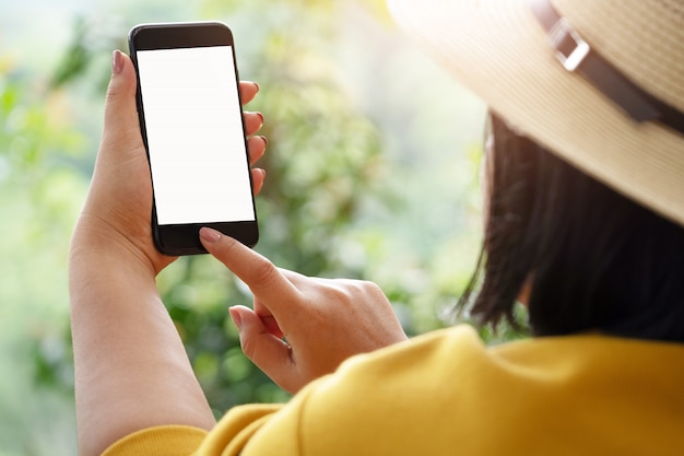 Woman's hand holding and using smartphone