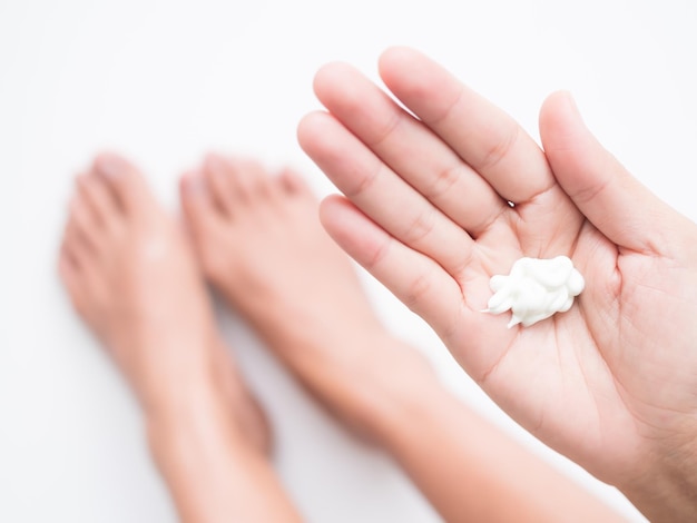 A woman's hand holds a cream that is on her palm.