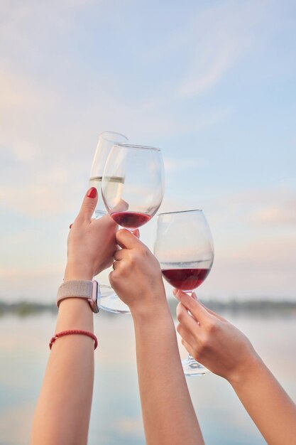 A woman's hand holds a glass of champagne a sparkling drink poured into a glass transparent glass a banquet closeup a party with friends