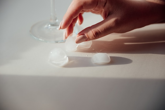 A woman's hand holds a glass with ice