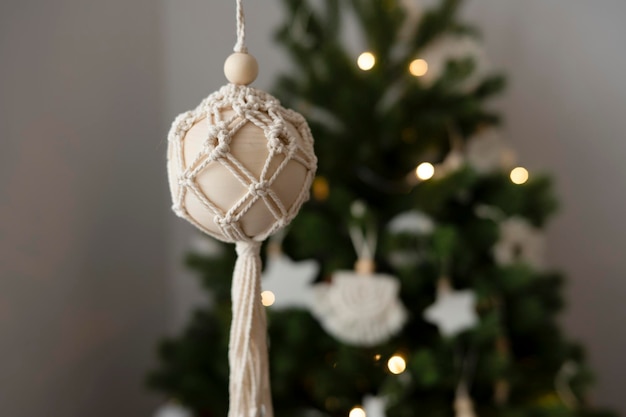 A woman's hand holds a handmade toy for the Christmas tree