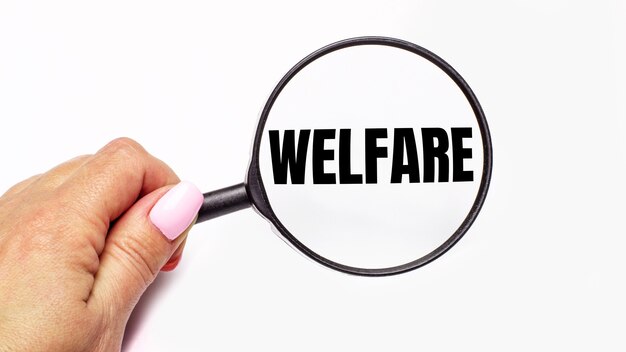 Женская рука держит увеличительное стекло с надписью WELFARE