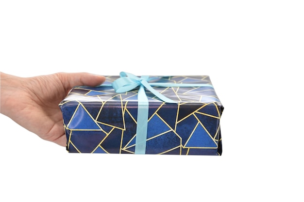 Photo a woman's hand holds out a large giftwrapped box tied with a blue ribbon
