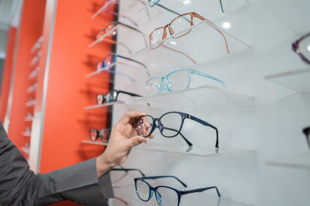 A woman's hand is holding a pair of glasses stuck to a window in the eye clinic