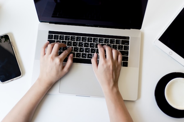 Photo the woman's hand is pressing on the keyboard of the laptop.