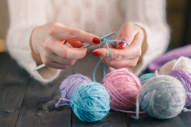 Woman's hand knitting scarf, handcraft.