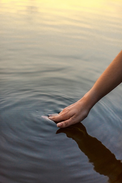 Woman's hand in the lake water