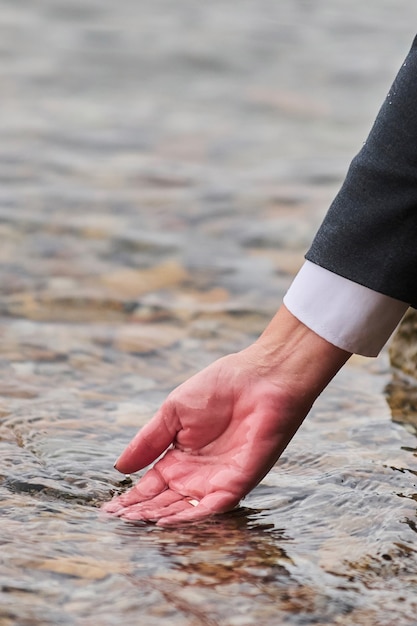 Woman's hand on the mattress touch water.