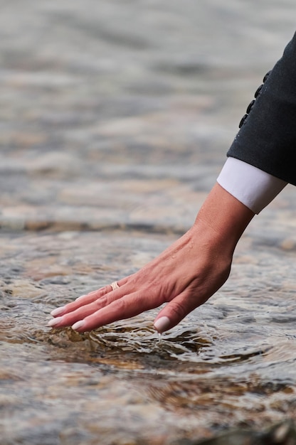 Woman's hand on the mattress touch water.