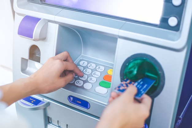 Woman's hand pressing PIN/pass code on ATM/bank machine keypad