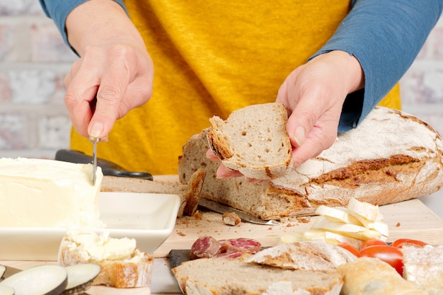 Woman's hand putting butter on a bread