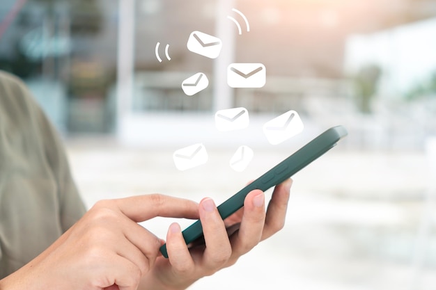 A woman's hand sends and receives emails on her smartphone Concept of business communication technology