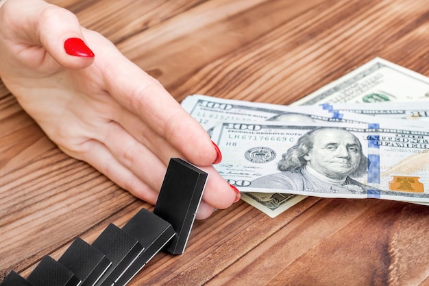 Photo woman's hand stops domino effect before money business concept