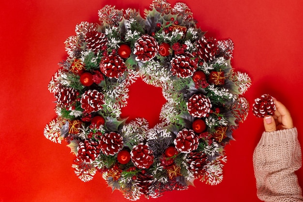 woman's hand in a sweater makes a Christmas wreath