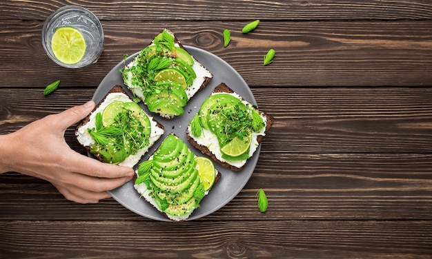 Woman's hand takes sandwich from gray plate