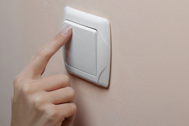 Woman's hand turning off the lights in a room