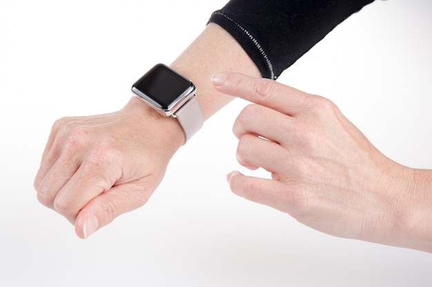 La mano della donna facendo uso di un orologio isolato