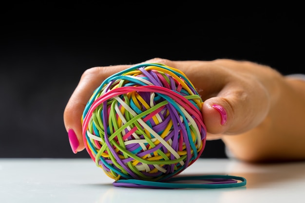 Woman's hand with colorful rubber bands ball