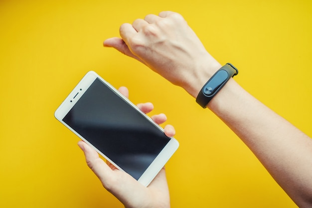 Woman's hand with fitness tracker and smartphone