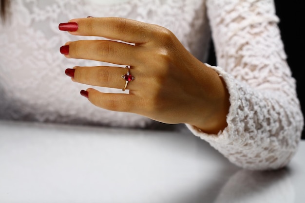 A woman's hand with a red stone ring