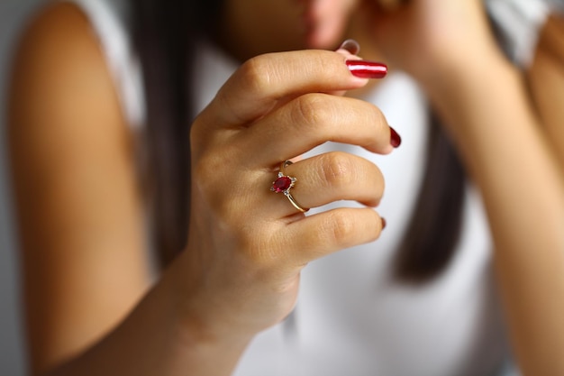 A woman's hand with a red and white ring on it