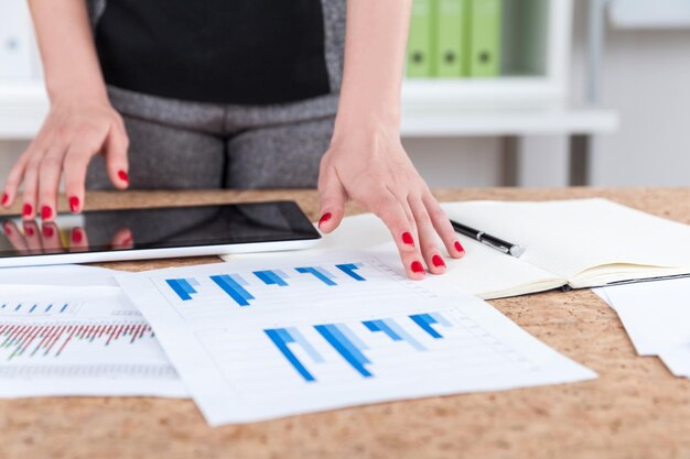 Woman's hand with tablet and graph