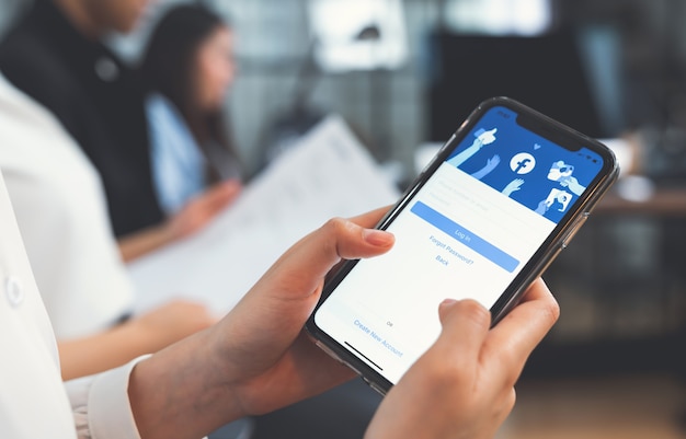 Photo woman's hands are pressing the facebook screen on smartphone