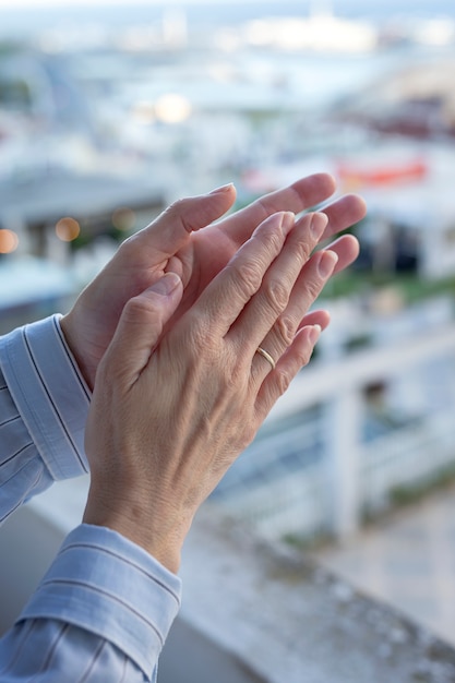 Woman's hands on the balcony to applaud medical staff for the fight against the coronavirus