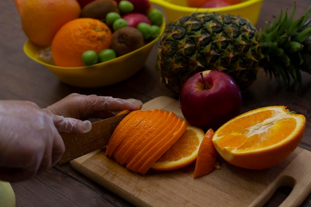 Woman's hands cutting fresh orange on kitchen