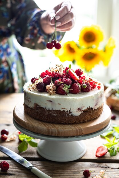 Woman's hands hold homemade berry cheesecake, selective focus.