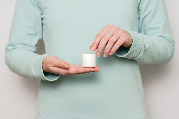 Woman's hands hold plastic jar container Cosmetic product